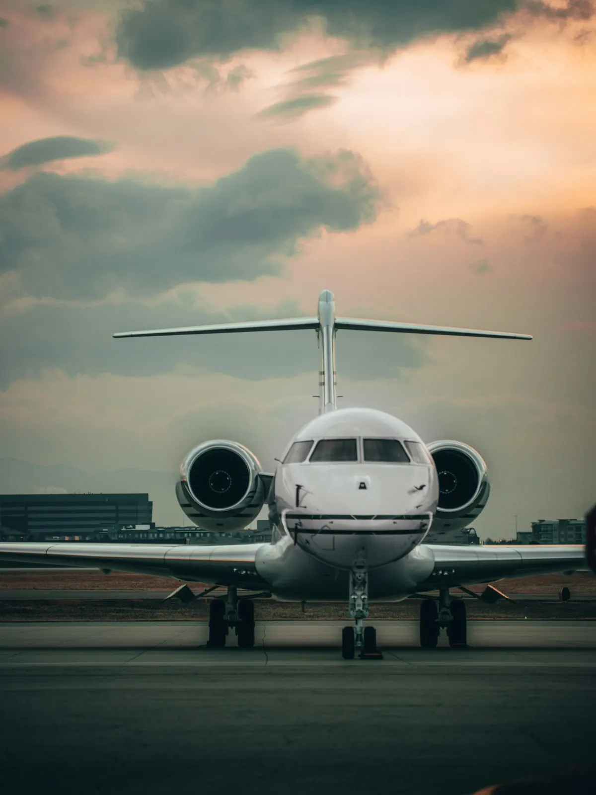 A business jet facing the camera on the ramp at dusk