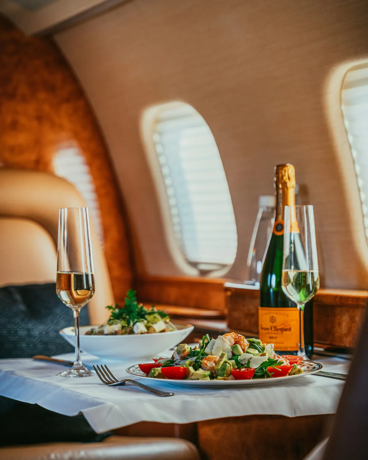 A table set with champagne in a private jet cabin