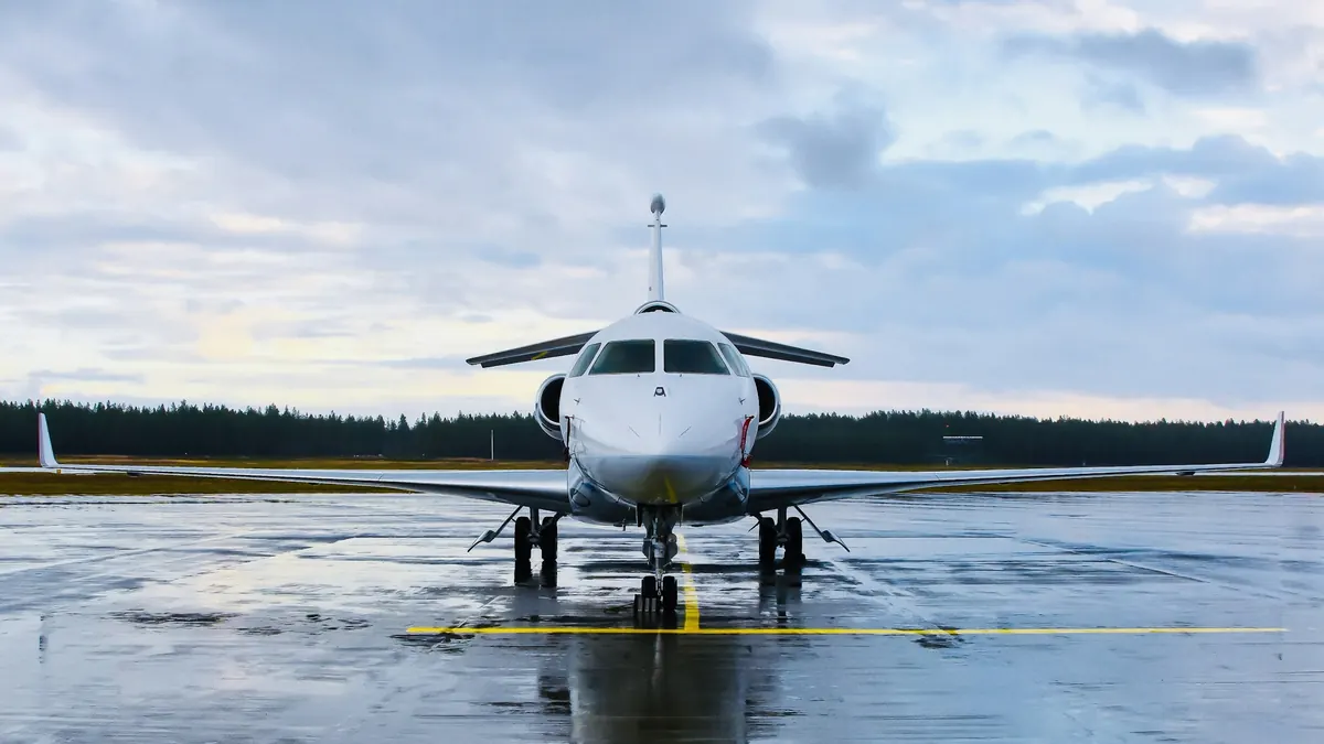 A business jet facing the camera on a wet runway