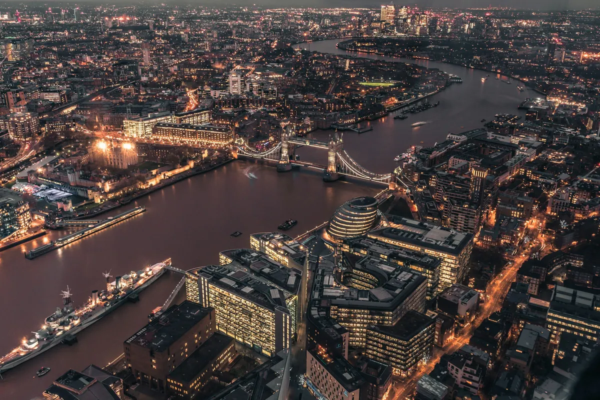 Tower Bridge and the Thames lit up at night, from above